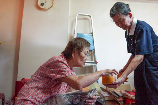 A volunteer ensures that all items—including a jumble of receipts, gets the permission of Grandma Wong before being discarded. Photo by Nichelle Chan