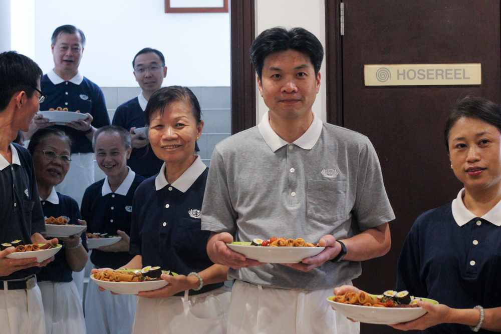 Volunteers queuing up to enter the main hall to serve the dishes. (Photo by Audrey Phang) 